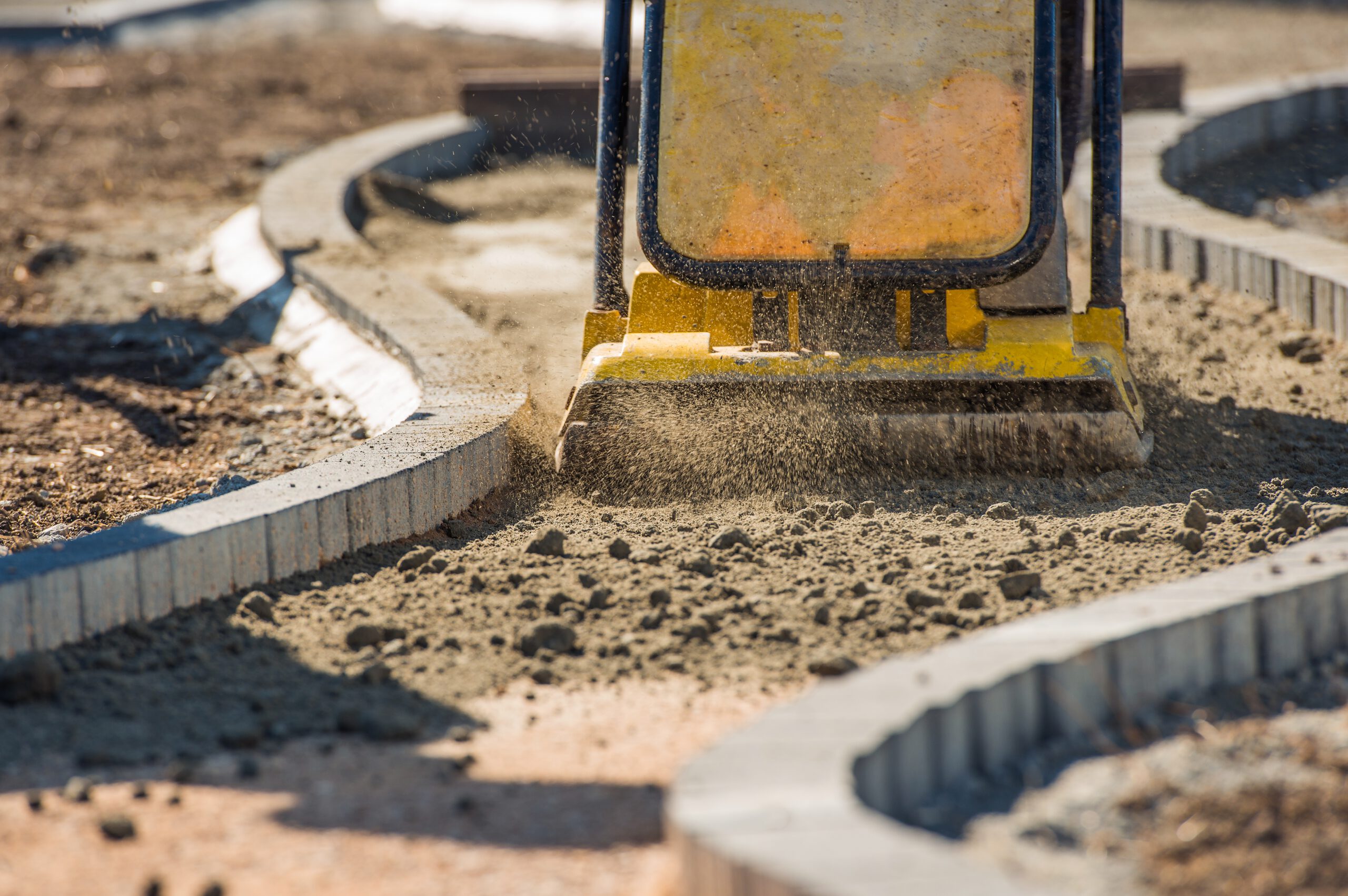 Concrete curb and gutter being formed in a commercial parking lot