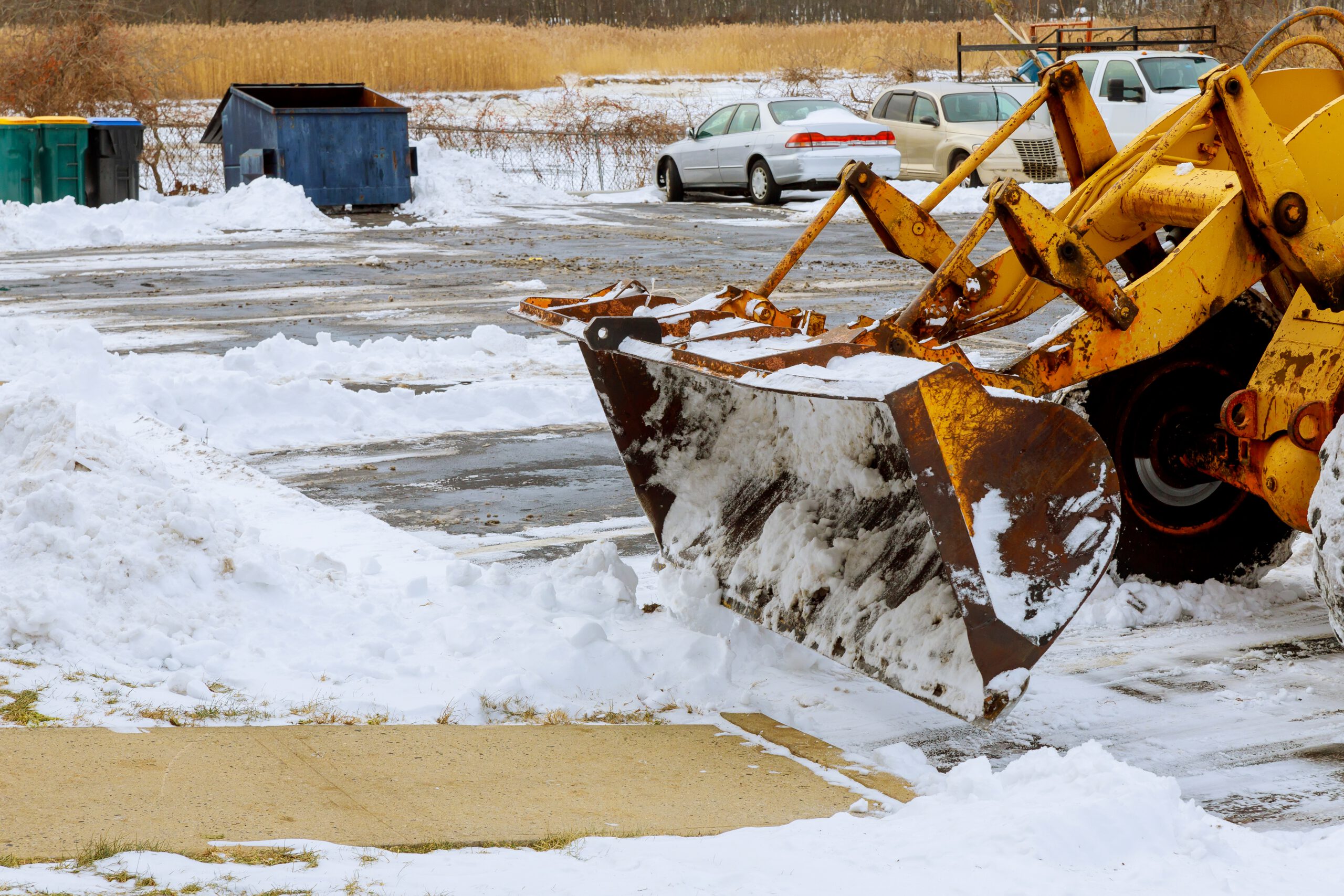 Plow clearing snow from a commercial parking lot