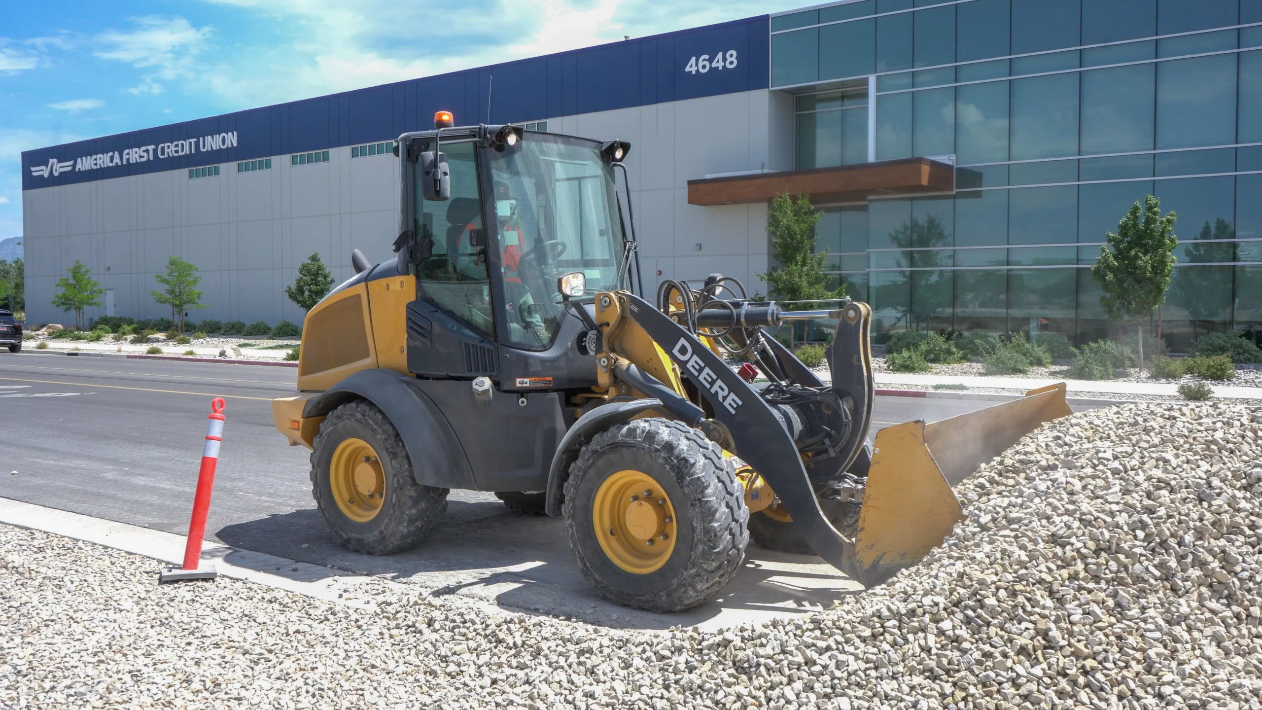 Skid steer grading soil on a commercial site